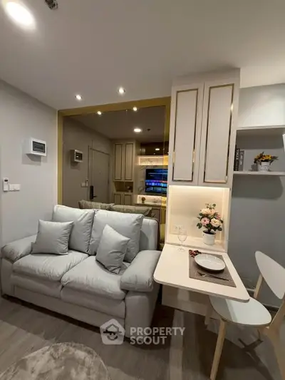 Modern living room with cozy sofa and stylish dining area in open layout apartment.
