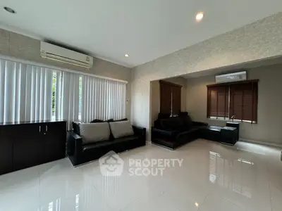 Spacious modern living room with sleek black furniture and large windows