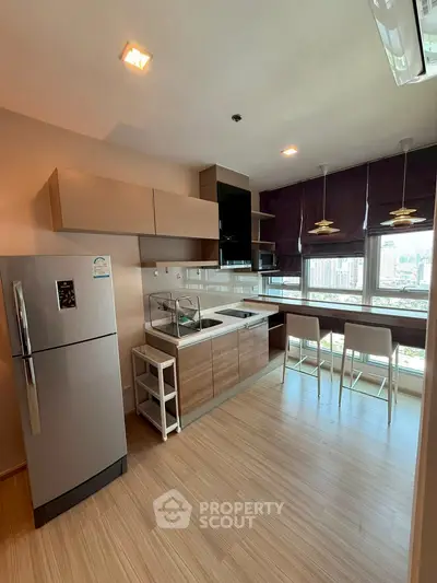 Modern kitchen with city view, featuring sleek cabinetry and breakfast bar.