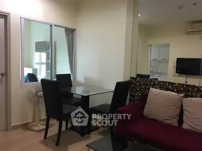 Cozy living room with modern furniture and glass dining table in a stylish apartment.
