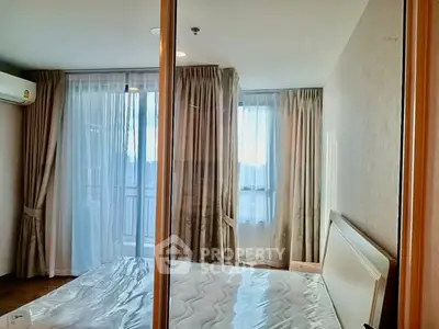 Bright bedroom with large windows and elegant curtains in modern apartment.