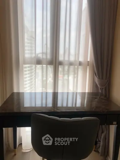 Cozy study area with marble desk and city view through large window.