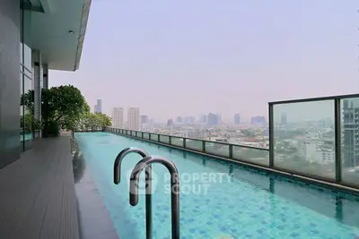 Stunning rooftop pool with panoramic city views in luxury high-rise building.