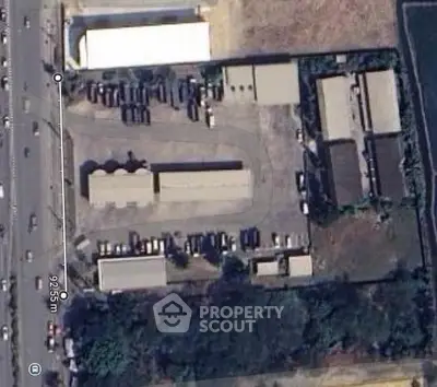 Aerial view of industrial property with multiple warehouses and parking area.