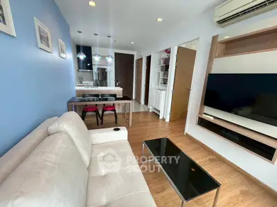 Modern living room with open kitchen, sleek furniture, and cozy ambiance