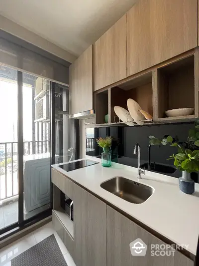 Modern kitchen with sleek cabinetry and balcony view in urban apartment