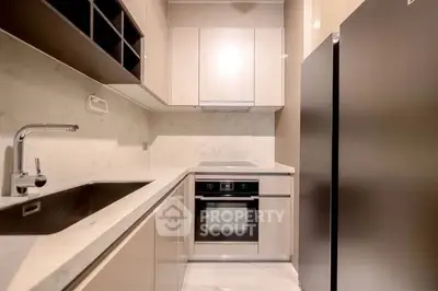 Modern kitchen with sleek cabinetry and built-in oven, perfect for culinary enthusiasts.
