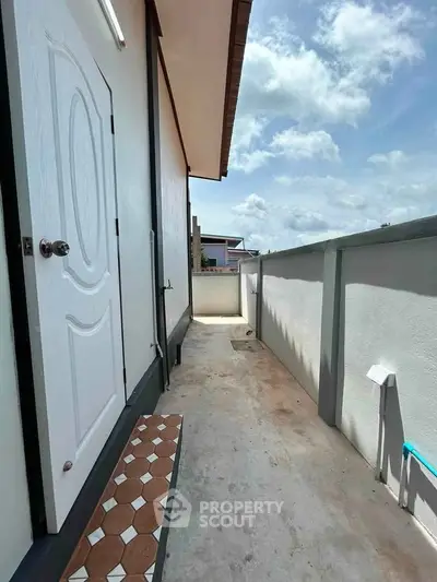 Charming balcony with sunny view and modern door, perfect for relaxation.