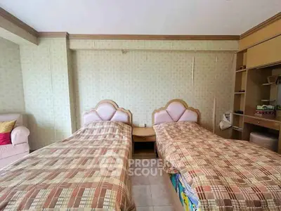 Cozy bedroom with twin beds and built-in storage, perfect for a comfortable stay.