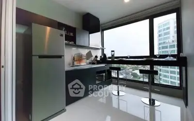 Modern kitchen with sleek design and city view, featuring stainless steel appliances and breakfast bar.