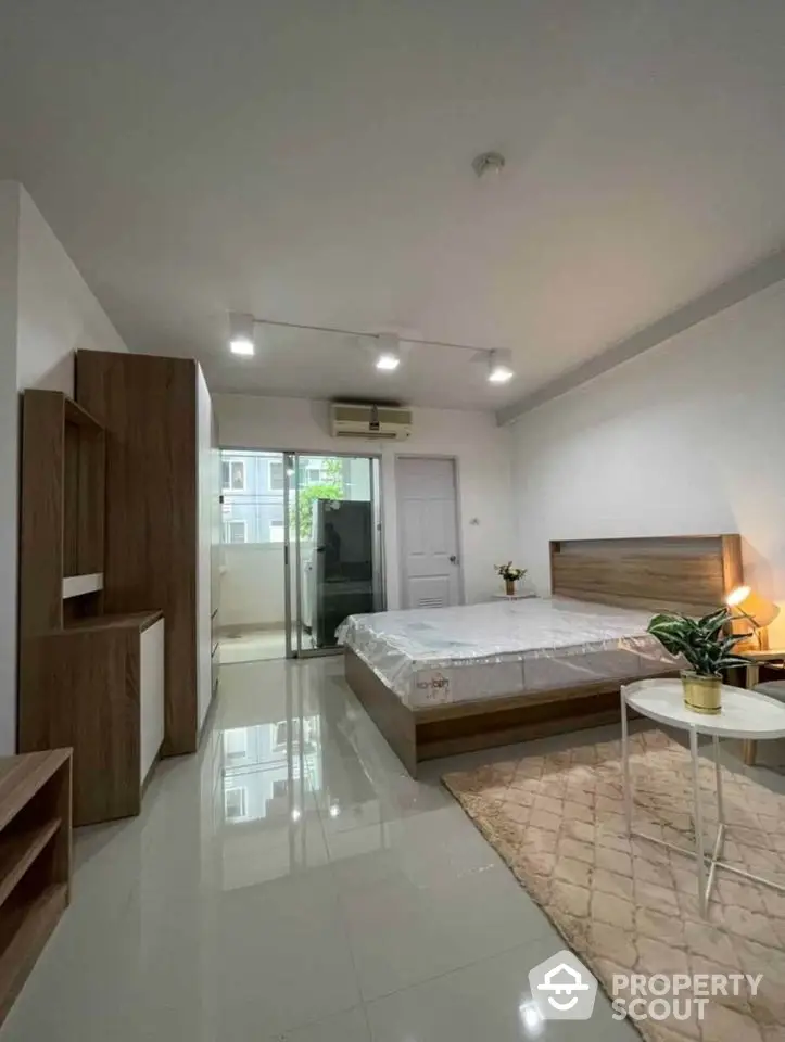 Modern bedroom with sleek furniture and natural light in a stylish apartment.