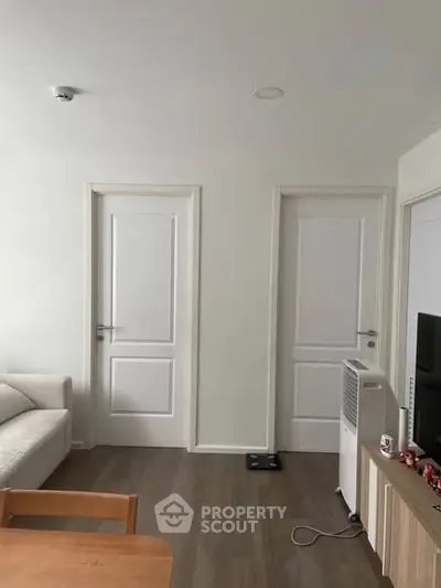 Modern living room with white doors and minimalist furniture