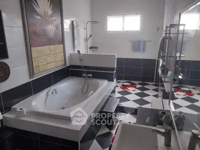 Luxurious bathroom with modern black and white tiles and large bathtub