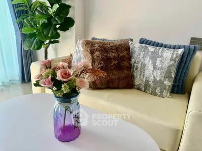 Chic living room with cozy sofa, plush cushions, and elegant floral arrangement, perfect for relaxation.