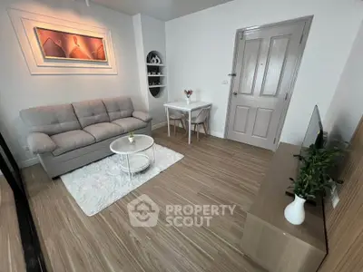 Modern living room with cozy sofa, stylish decor, and wooden flooring in a contemporary apartment.