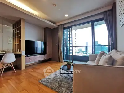 Modern living room with large window and city view, featuring stylish furniture and wooden flooring.