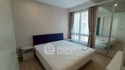 Modern bedroom with large window and mirrored closet doors