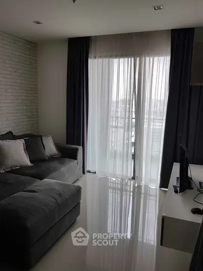 Modern living room with large sofa and balcony view