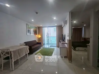 Spacious open-plan living room with modern decor and balcony access