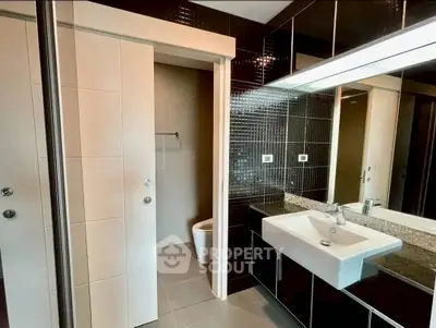 Modern bathroom with sleek black tiles and white fixtures