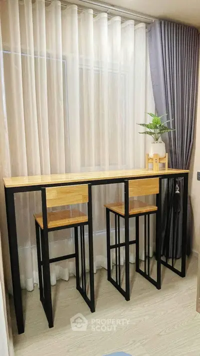 Modern minimalist study area with sleek wooden desk and chairs, perfect for compact spaces.