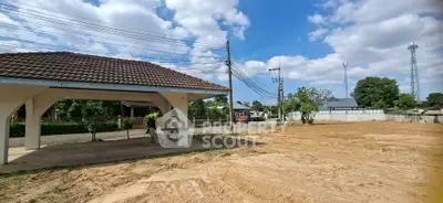 Spacious land plot with covered patio and clear blue sky, ideal for development.