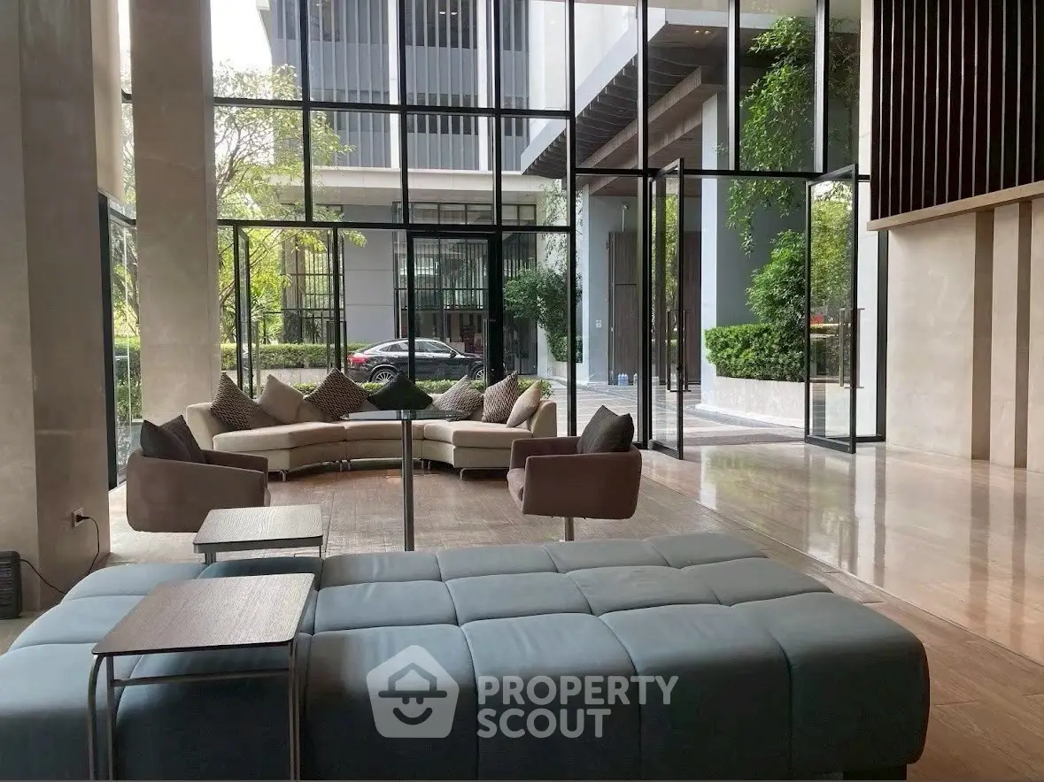 Luxurious modern living room with floor-to-ceiling windows and stylish furniture in a high-end property.