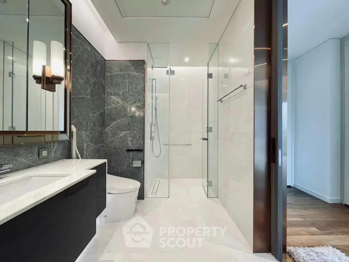 Luxurious modern bathroom with marble finishes and glass shower enclosure