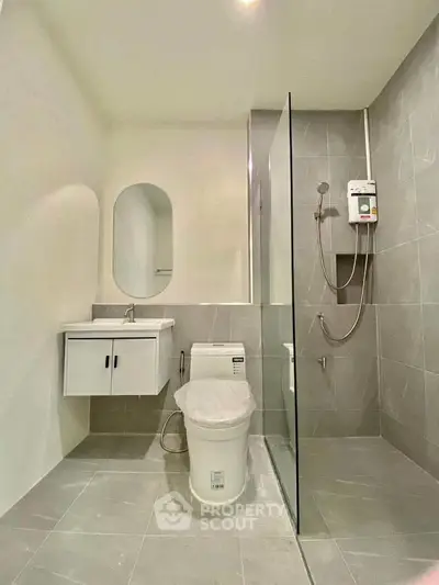 Modern bathroom with sleek design, featuring a glass shower enclosure and contemporary fixtures.
