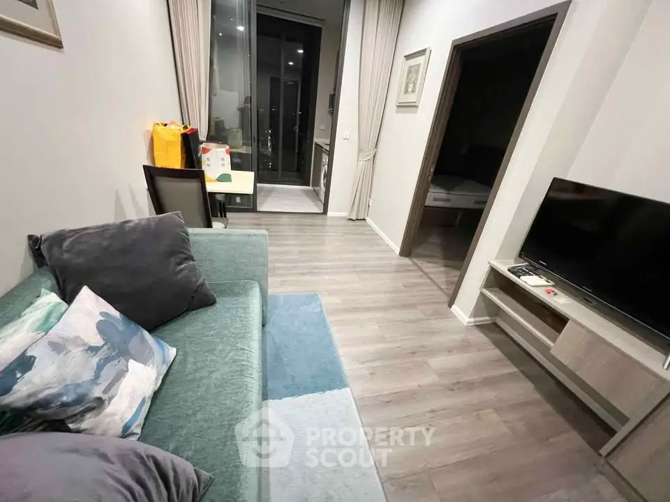 Modern living room with sleek design and balcony access, featuring stylish furniture and a cozy atmosphere.