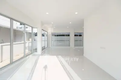 Spacious and bright modern living room with large windows and glossy floors.