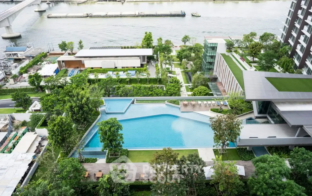 Luxurious riverside apartment complex with stunning pool and lush gardens.