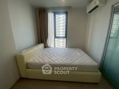 Cozy bedroom with modern design and large window offering city views, featuring a comfortable bed and air conditioning.