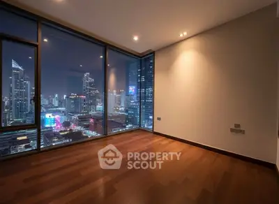 Stunning city view from modern high-rise apartment with floor-to-ceiling windows.