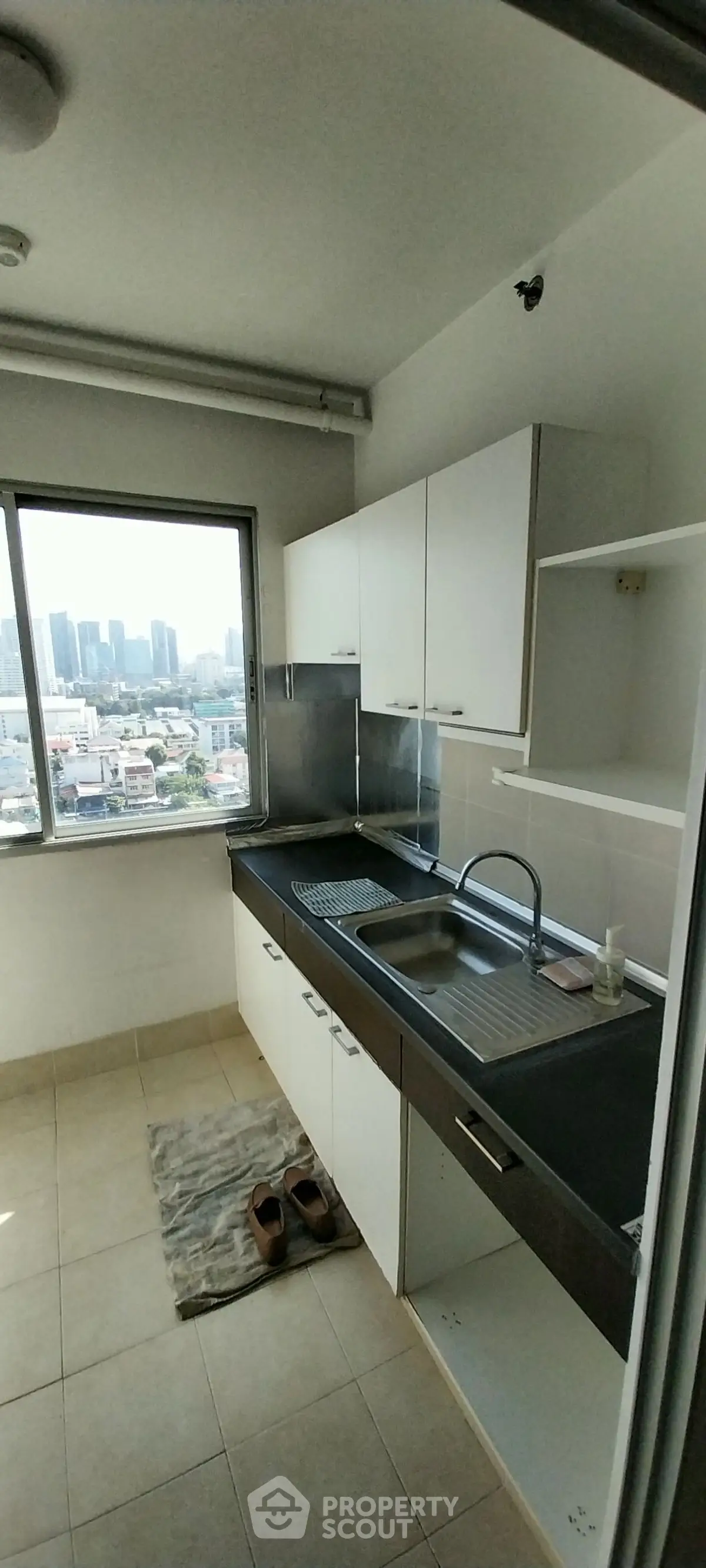 Modern kitchen with city view, sleek cabinetry, and ample natural light.