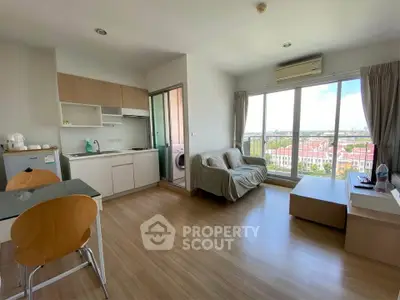 Modern open-plan living room with kitchen and balcony view in a bright apartment.