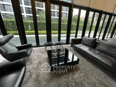 Luxurious modern living room with sleek furniture and large windows offering garden views.