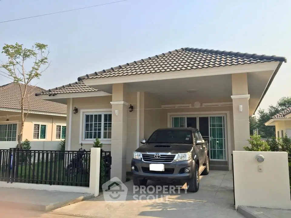 Charming single-story house with driveway and car, featuring modern design and tiled roof.