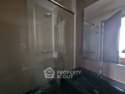 Modern bathroom with sleek shower and dark countertop