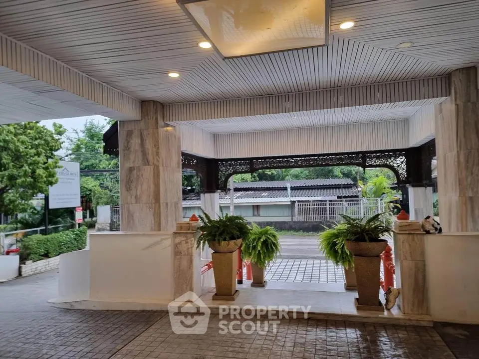 Elegant building entrance with lush greenery and modern design
