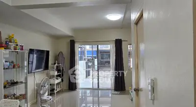 Spacious living room with modern decor and sliding glass doors leading to outdoor area.