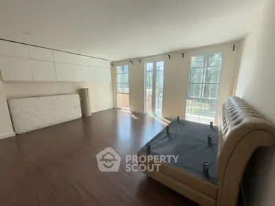 Spacious unfurnished living room with large windows and hardwood floors