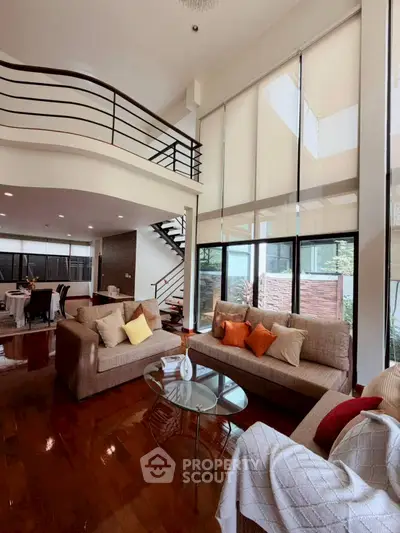 Spacious modern living room with high ceilings and elegant staircase in luxury home