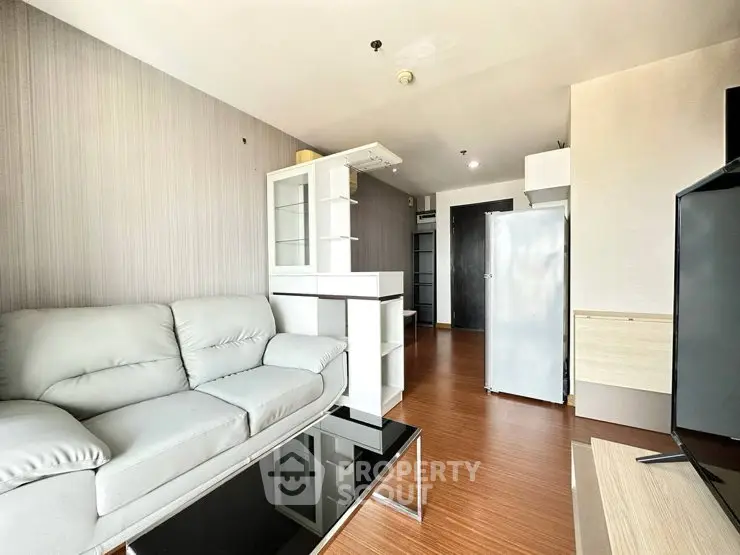 Modern living room with sleek furniture and wooden flooring in a stylish apartment.