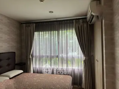 Cozy bedroom with large window and elegant curtains