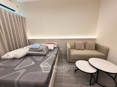 Modern bedroom with cozy sofa and stylish decor in a contemporary apartment.