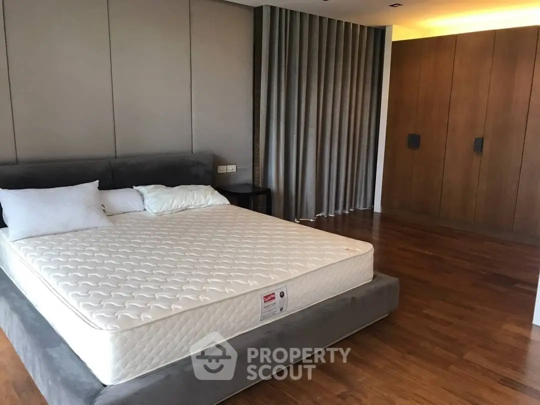 Spacious modern bedroom with elegant wooden flooring and stylish decor