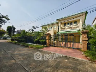 Charming two-story house with green roof and spacious front yard in a serene neighborhood.