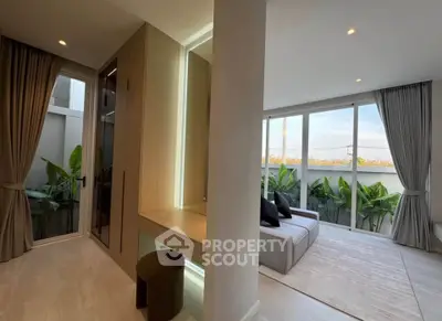 Modern living room with large windows and stylish decor, offering a bright and inviting atmosphere.