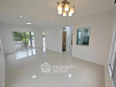 Spacious modern living room with large windows and elegant lighting